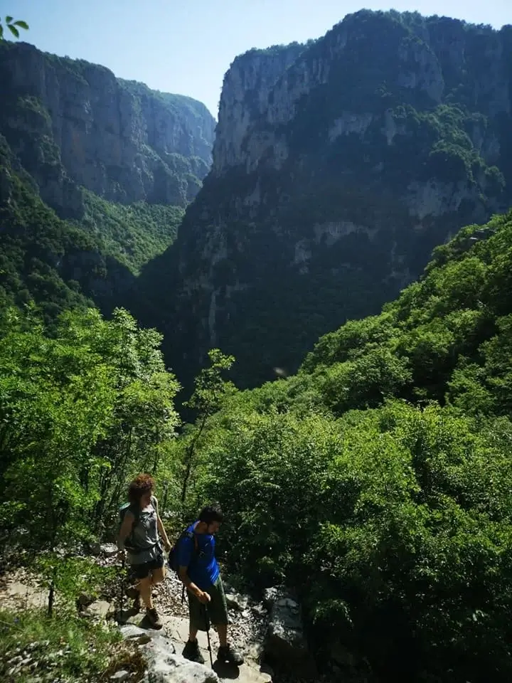 Hiking beneath the immense limestone walls of Vikos Gorge