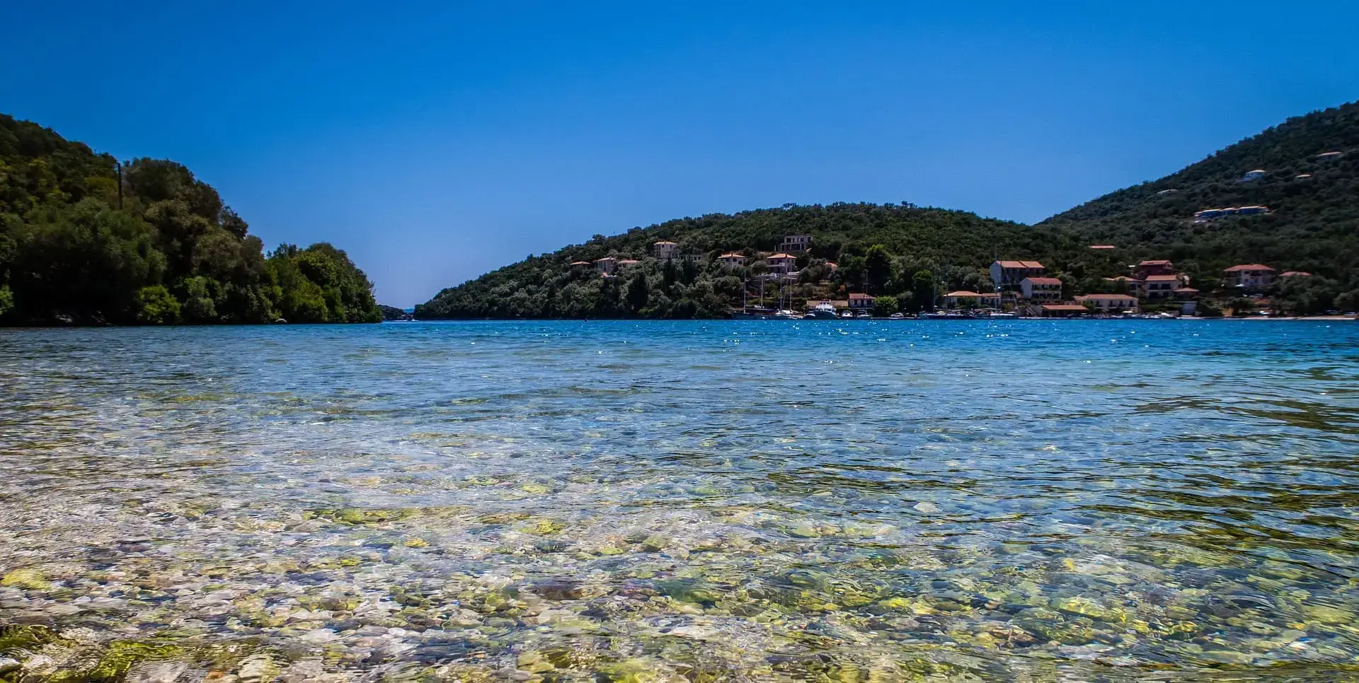 A quiet coastal village beside clear blue water in Greece